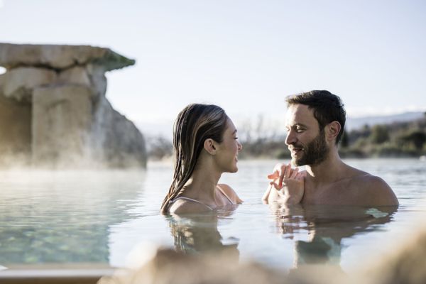 Paar im Thermalwasser-pool im Adler Spa Resort Thermae in der Toskana, Italien